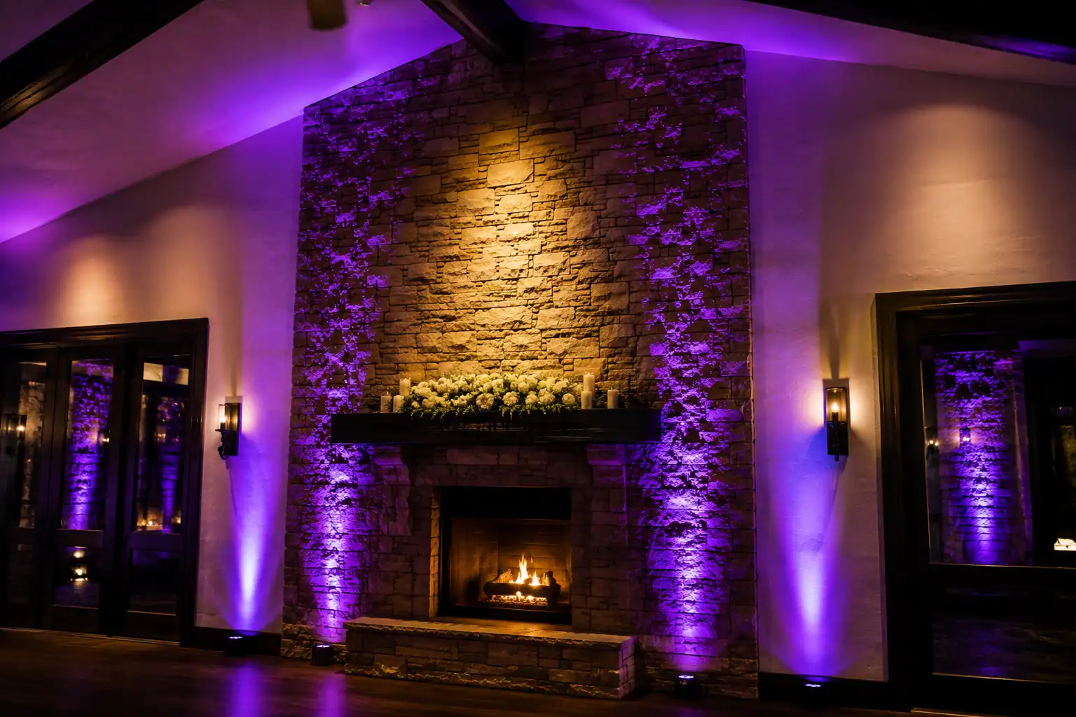 Purple and amber architectural uplighting illuminating a stone fireplace at an Orlando event venue