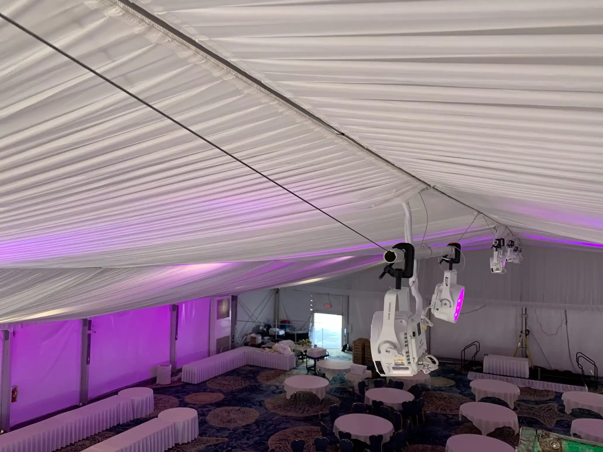 Purple color-changing LED lighting illuminating the ceiling of a large event tent