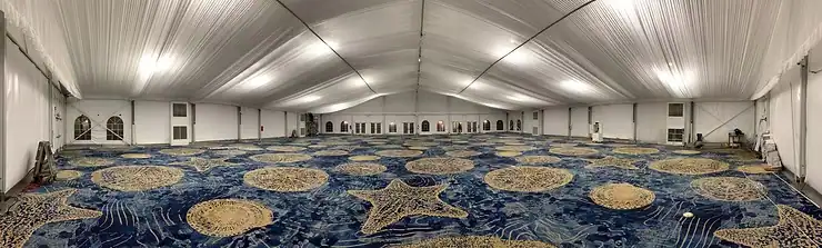 Wide-angle view of finished event tent with evenly diffused white house lighting