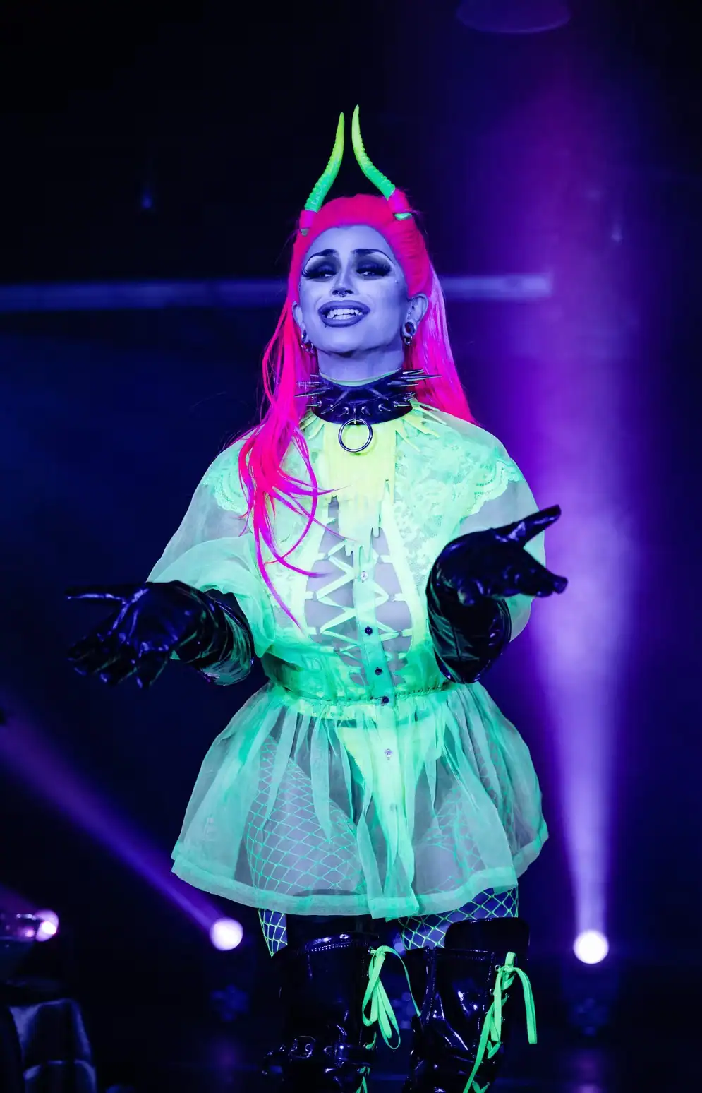 Halloween performer illuminated by blacklight and colorful theatrical lighting