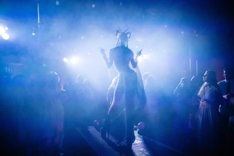Costumed performer surrounded by theatrical lighting and haze at a Halloween event