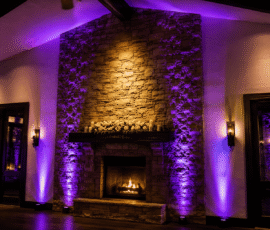 Permanent uplighting illuminating a stone fireplace at an Orlando event venue