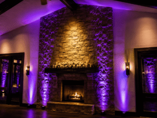 Permanent uplighting illuminating a stone fireplace at an Orlando event venue