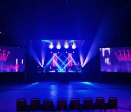 Concert stage lighting with moving beams and large video screens for a live production in Orlando