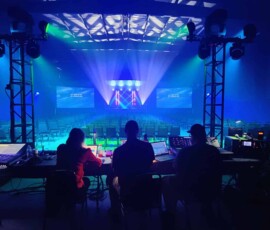 Professional stage lighting with blue beams and production control for a corporate event in Orlando