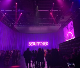 Custom projected graphic on a draped event wall with magenta stage lighting