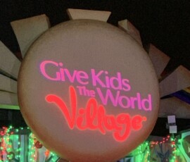Give Kids The World Village logo projected onto a large circular event feature