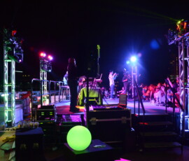 Colorful live event stage lighting with truss-mounted fixtures and illuminated stage in Orlando