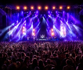 Professional stage lighting illuminating a live concert performance in Orlando with dynamic LED fixtures, moving lights, and large audience.