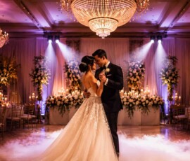Bride and groom sharing their first dance beneath crystal chandeliers with elegant wedding lighting, uplighting, and low-lying fog designed by TYLERLIGHT in Orlando, Florida.