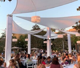 Hanging chandeliers beneath white fabric canopies at an outdoor Orlando event reception