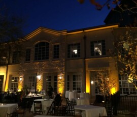 Warm permanent uplighting illuminating the exterior architecture of an Orlando venue at night