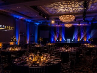 Professional event lighting installation in an Orlando ballroom featuring custom stage lighting, uplighting, GOBO logo projection, and corporate event production by TYLERLIGHT.